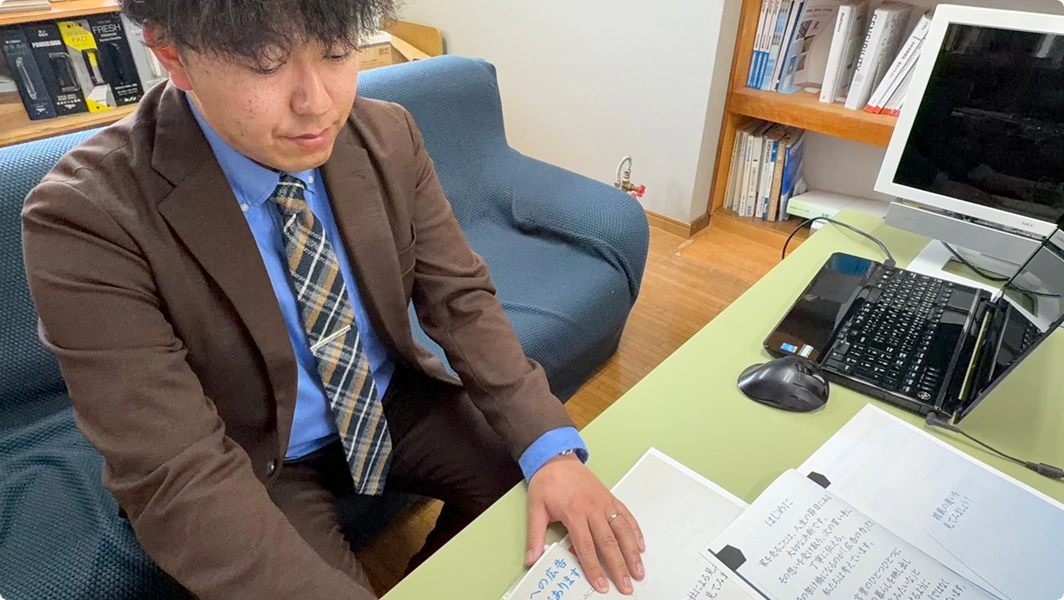 デスクで書類を確認する担当スタッフ